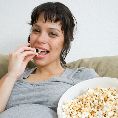 Pregnant woman eating popcorn