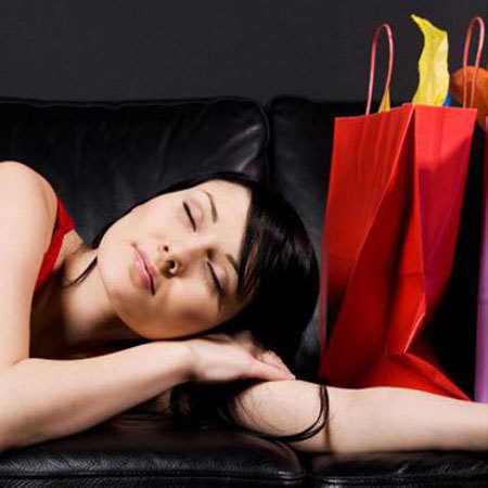 Woman lying on sofa with shopping bags