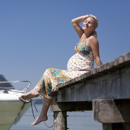Pregnant lady sitting on a jetty